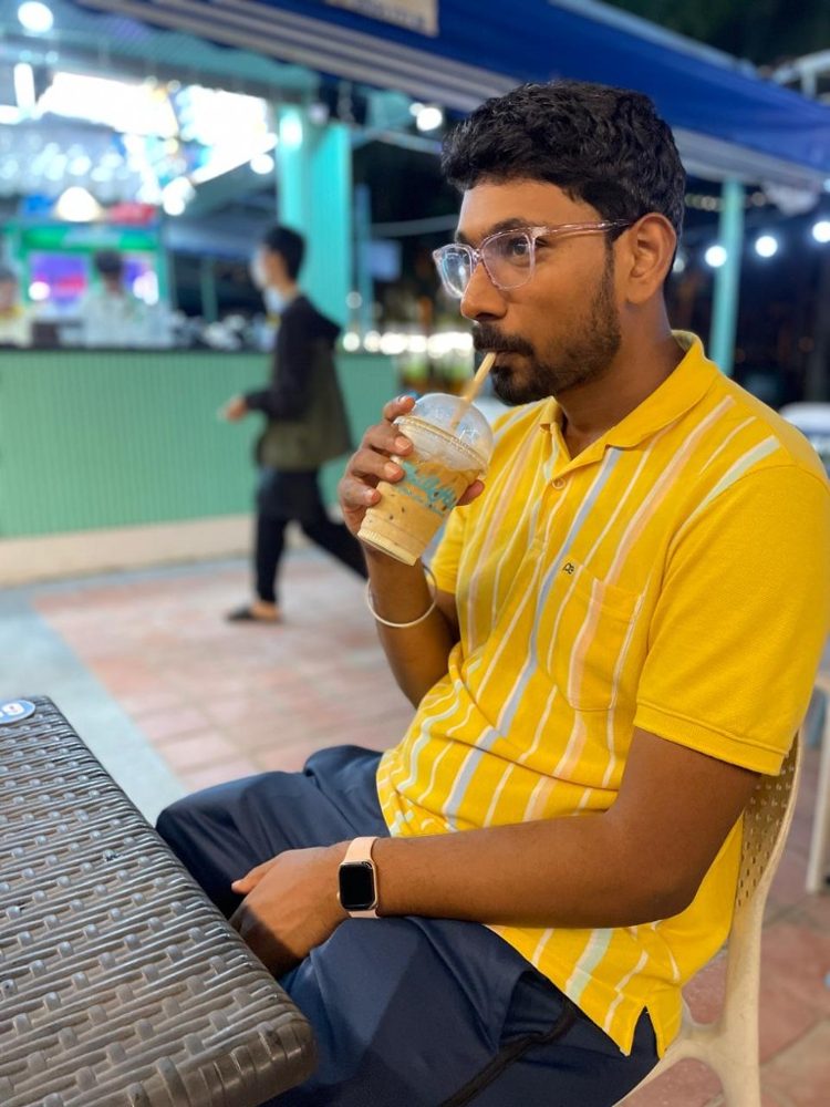 Ram sipping an iced coffee at a street café