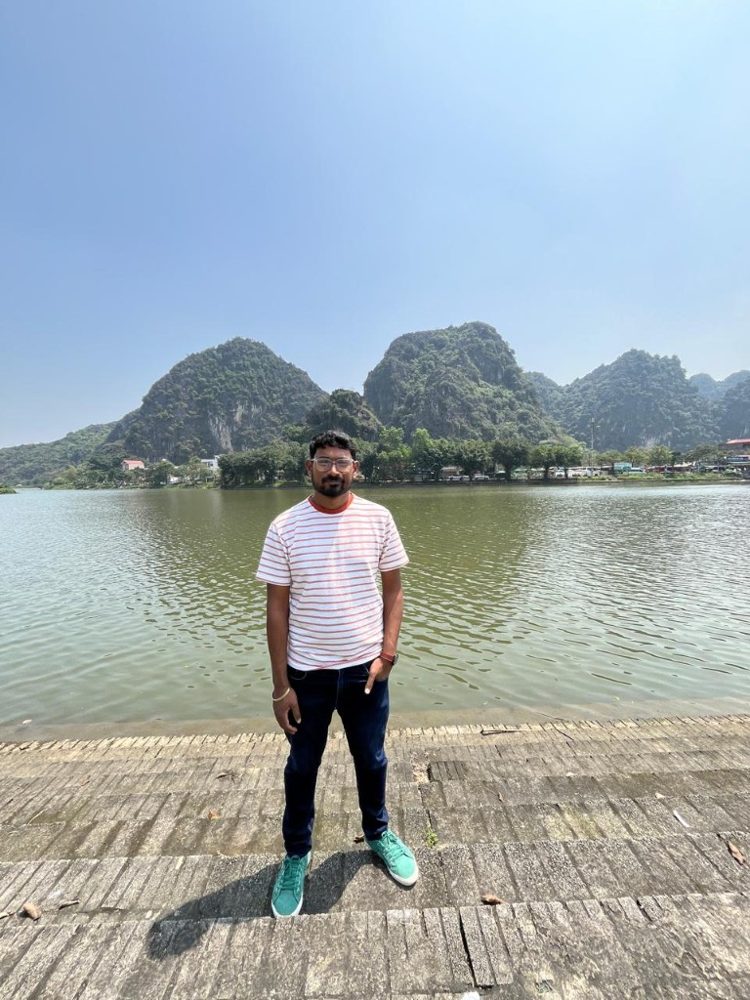 Ram standing by a lake with limestone hills behind