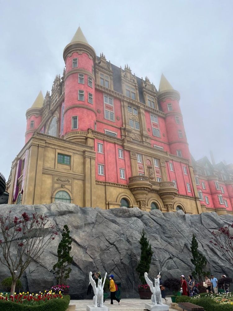 Pink fairytale castle on a rock in the mist at Ba Na Hills