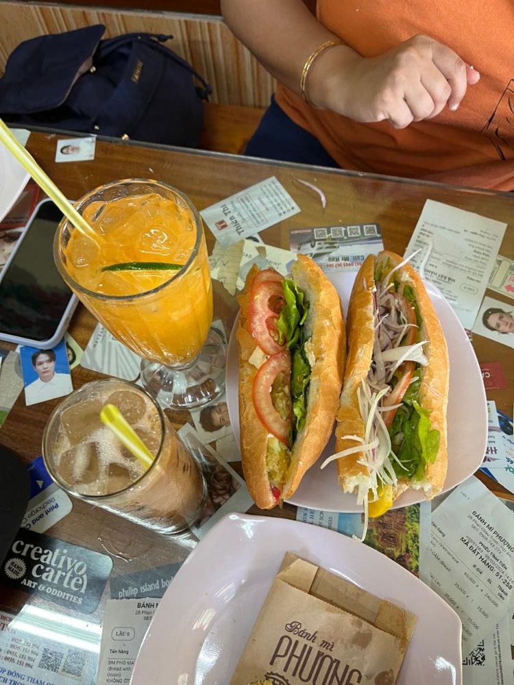 Two bánh mì sandwiches and iced drinks at Bánh Mì Phượng