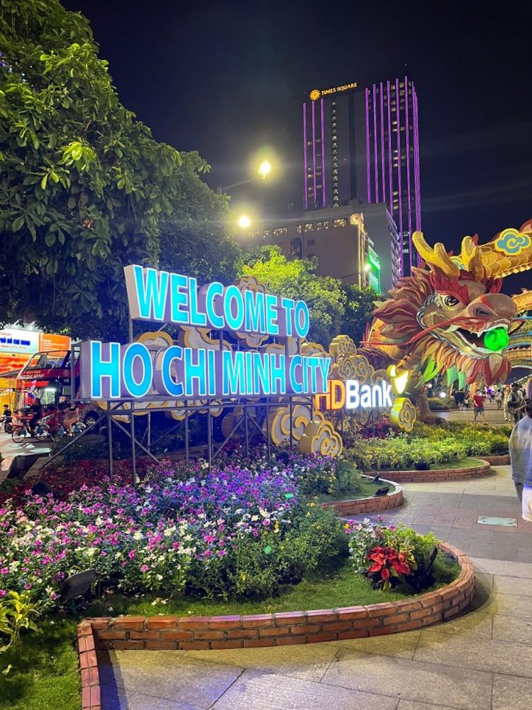 Welcome to Ho Chi Minh City sign lit up at night with a dragon display